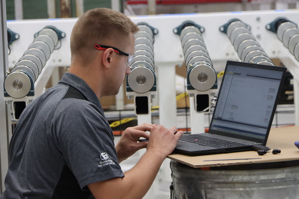 QComp Engineer Working by Glass Conveyor