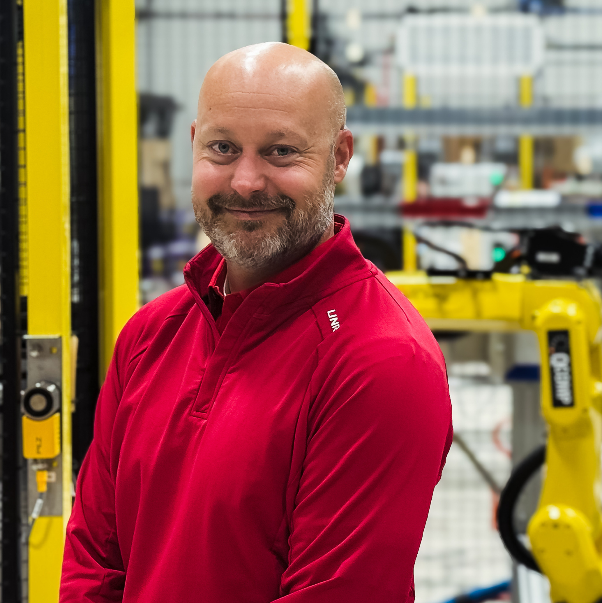 Pete Rogers in red shirt in front of yellow robot